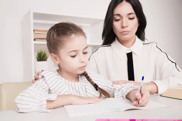 Moeder met dochter studeren thuis. Homwschool concept. — Stockfoto