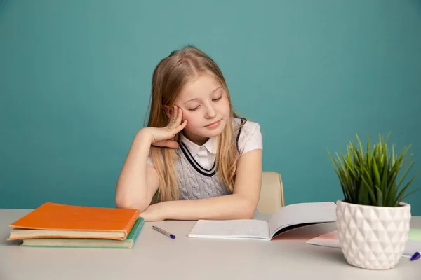 Unavená dívka s knihami na pozadí školní tabule, která se dívá na kameru. Místo pro text — Stock fotografie