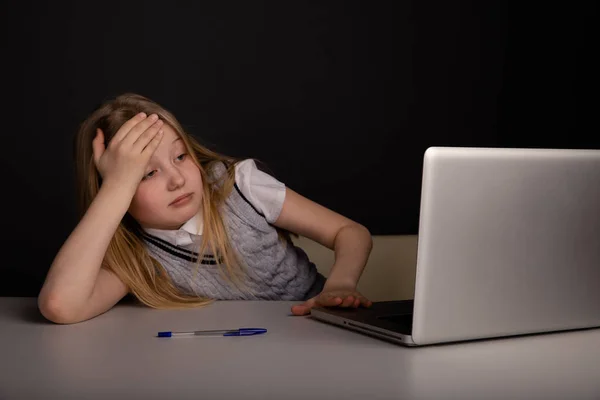Znudzony i zmęczony dziewczynka siedzi wprzód komputera. Koncepcja mdłości i bólu głowy. — Zdjęcie stockowe