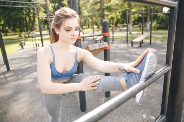 Summer outdoor training. Sporty woman doing gym in the park.
