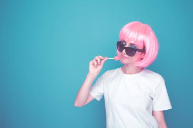 Mavi bir odada lolipop ile bir whit t-shurt ve siyah gözlük bautiful 90s kız.