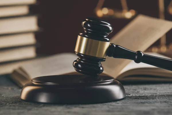 法の概念 - 青の背景に法廷や法施行のオフィスでテーブルの木製裁判官小槌を持ったオープン法の本. — ストック写真