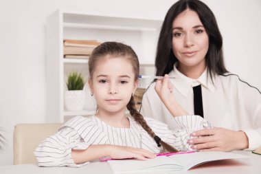 Güzel anne ile sevimli kız oturma ile kitap içinde the oda at ev.