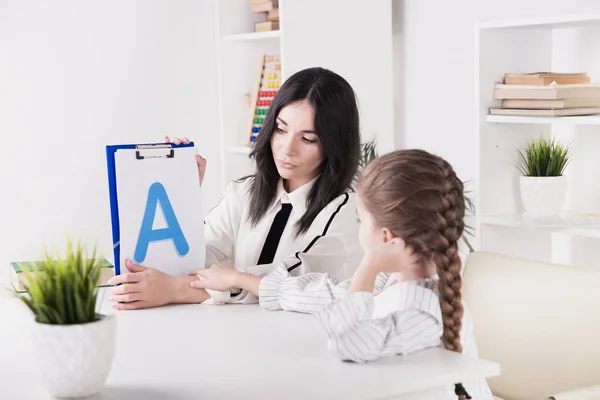 Sprachtherapiekonzept. Kind mit Therapeut lernt gemeinsam Buchstaben. — Stockfoto