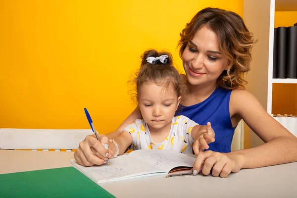 Glückliche Mutter und Tochter lernen gemeinsam zu Hause. — Stockfoto