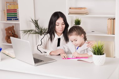 Evde eğitim kavramı. Öğretmen ve kız birlikte ev ödevi yapıyor.