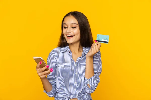 Happy surprised woman with phone and credit card. Shopping online concept.