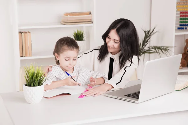 家庭教育の概念。家庭教師と女の子が一緒に宿題をしている. — ストック写真
