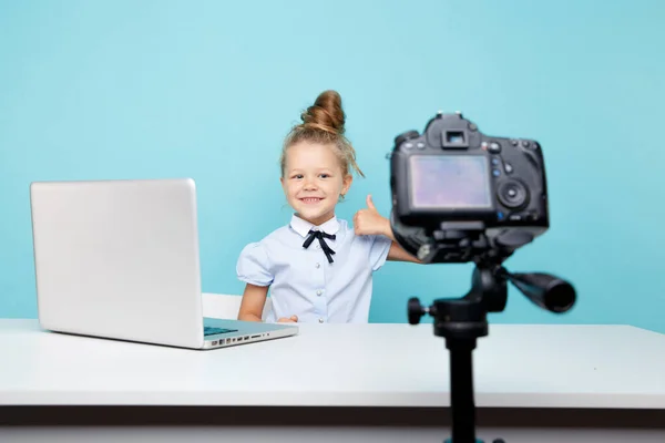 Mavi stüdyodaki bilgisayarın önünde oturan kız blogcu kameraya video kaydediyor.. — Stok fotoğraf