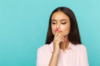 Düşünen kadın mavi arka planda izole poz.