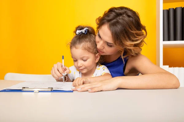 Enfant heureux avec mère dans une salle de jeux dessinant ensemble . — Photo