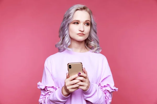 Woman using mobile phone isolated in the pink room. — Stock fotografie