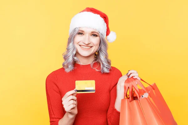 Xmas shopping online concept. Christmas girl holding credit card and big bags. — Stockfoto