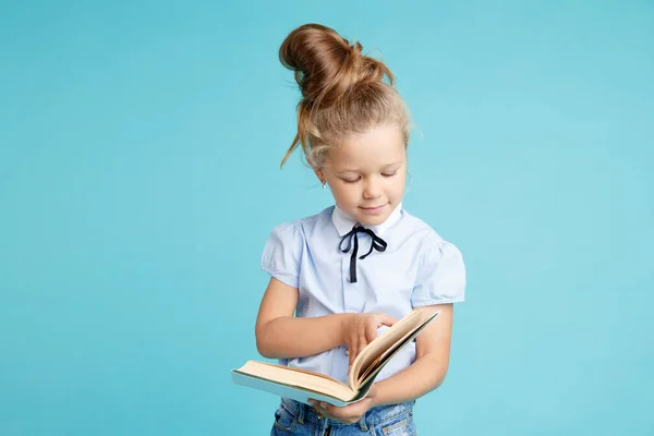 Handsome girl holding white book in hands in the blue room. — Stock Photo, Image