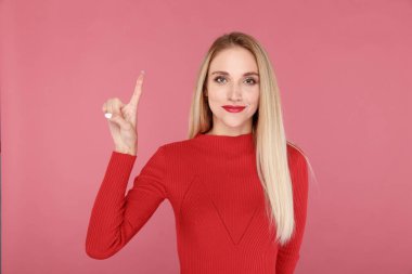 Mutlu kadın gülümsüyor ve soyutlanmış bir şeyi işaret ediyor.