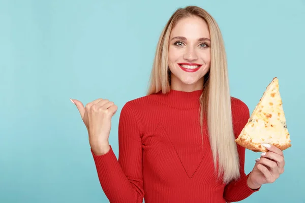 Female person eating pizza and pointing to the left isolated.