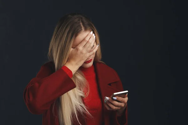 Triste femme stressée avec téléphone isolé dans la chambre noire . — Photo