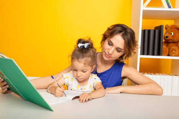 Gelukkig kind met moeder in een speelkamer tekenen samen. — Stockfoto