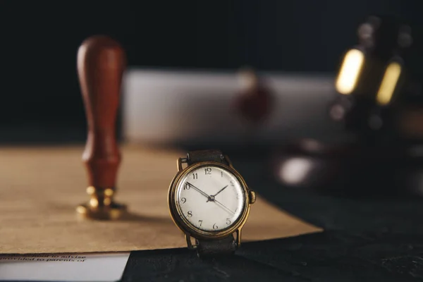 Sello notarial y martillo de madera con reloj sobre la mesa. —  Fotos de Stock