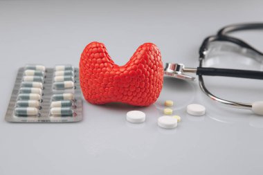 Tiroit tedavisi resim konsepti. İlaçlı kırmızı bez ve steteskop, sağlık hizmetleri.