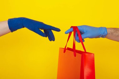 Karantina zamanında teslimat. Biri kırmızı çantayı başka birine veriyor..