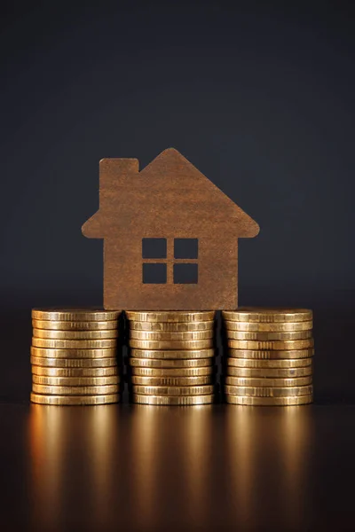 Modelo de la casa en monedas pila aislado fondo gris. Concepto de inversión inmobiliaria . — Foto de Stock