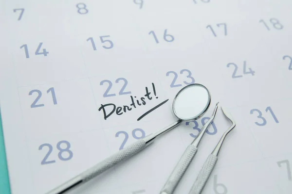 Dental health and teethcare concept. Dentist appointment in calendar and professional dental tools.