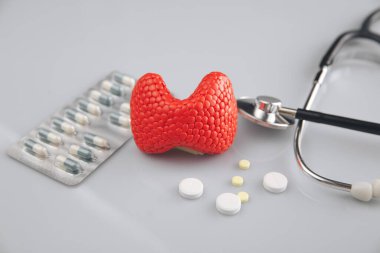 Tiroit tedavisi resim konsepti. İlaçlı kırmızı bez ve steteskop, sağlık hizmetleri.