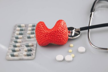 Tiroit tedavisi resim konsepti. İlaçlı kırmızı bez ve steteskop, sağlık hizmetleri.