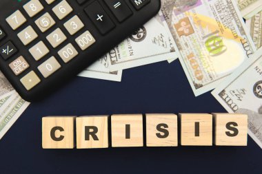 Kriz Yönetim Konsepti. Küpler için kriz kelimesi. Mavi arkaplanda hesap makinesi ve para
