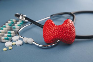 Tiroit tedavisi resim konsepti. İlaçlı kırmızı bez ve steteskop, sağlık hizmetleri.