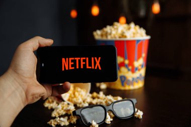 Tula Rusya 16.01.20: Telefon ekranında Netflix ve masada gözlüklü patlamış mısır.