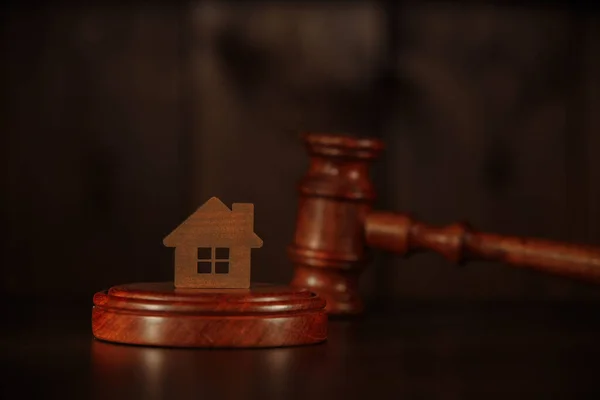 Концепция ипотеки. Деревянный молоток и дом за столом . — стоковое фото