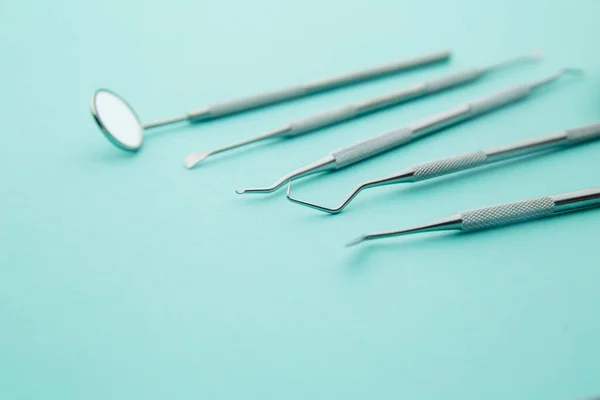 Professional Dentist tools in dental office: dentist mirror, forceps curved, explorer curved, dental explorer angular and explorer curved with chip, right. Dental Hygiene and Health conceptual image
