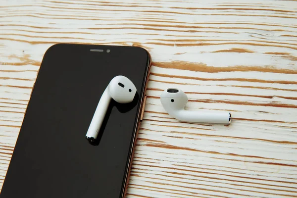 Tula Russia 16.01.20: Apple AirPods wireless Bluetooth headphones for Apple iPhone. New Apple Earpods Airpods on a blue background. Copy space — Stock Photo, Image