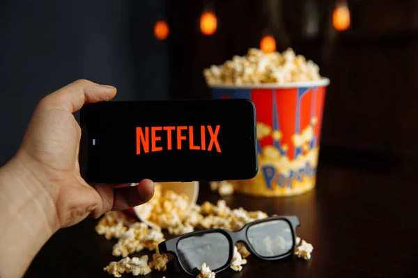 Tula Russia 16.01.20: Netflix on the phone screen and popcorn with glasses on the table. — Stock Photo, Image