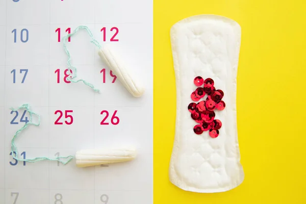 Menstruationskalender med bomullstamponger, sanitetsbindor, röda glitter. Kvinnokritiska dagar, hygieniskt skydd för kvinnor — Stockfoto