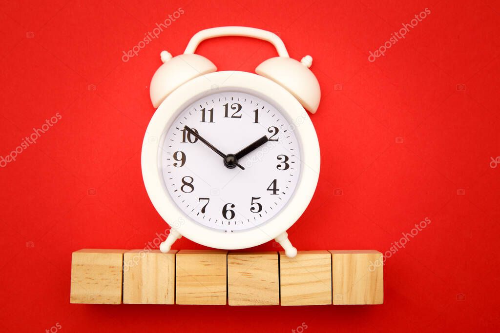 Six wooden cubes with space for text and alarm clock on red background. Time is money concept. Time-limit. Business deadline. Copy space
