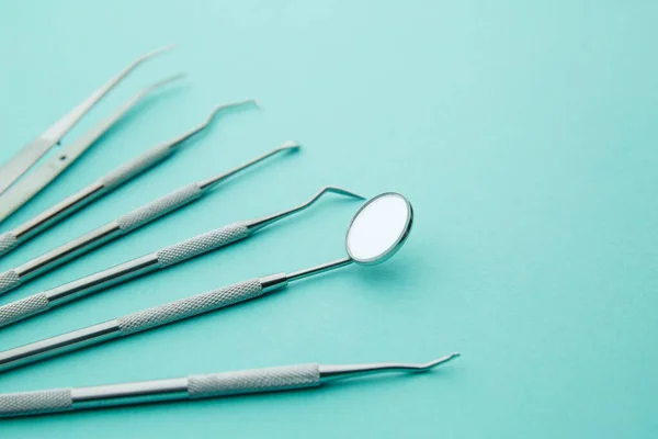 Concetto di salute dentale e cura dei denti. Utensili dentali, specchi, spatole, pinzette su fondo blu — Foto Stock