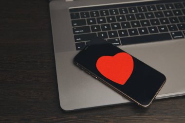 Masanın üzerinde kırmızı kalpler olan telefon.