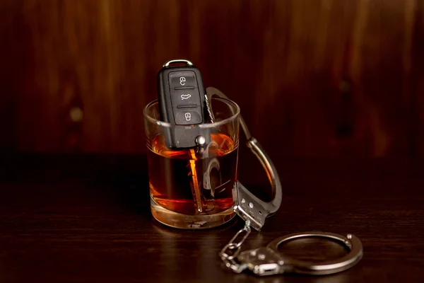 Whiskey with car keys and handcuffs. Concept for drinking and driving — Stock Photo, Image