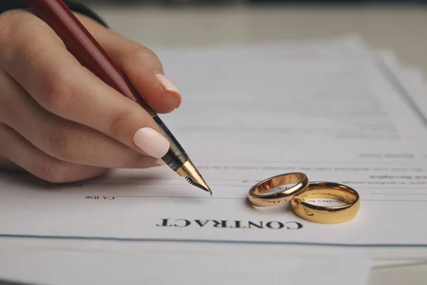 Hands of wife, husband signing decree of divorce, dissolution, canceling marriage, legal separation documents, filing divorce papers or premarital agreement prepared by lawyer. Wedding ring — Stock Photo, Image