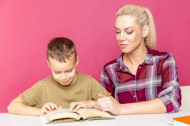 Annesiyle ödev yapan küçük bir okul çocuğu, aile içi işbirliği, ebeveynlik.