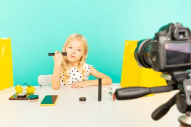 Evde kameranın önünde vlog için konuşan mutlu kız. Genç güzellik blogcusu İnternet için video dersi kaydediyor.
