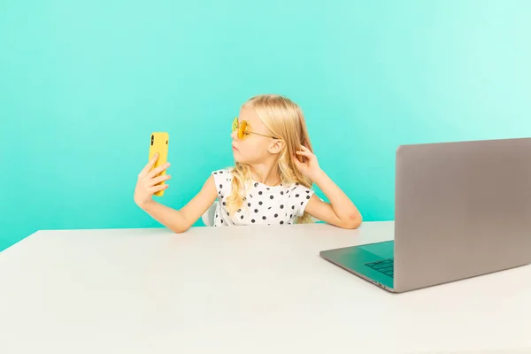 Gelukkig meisje in de blauwe studio spreekt voor de camera voor vlog. Werken als blogger, video-tutorial opnemen voor internet. — Stockfoto