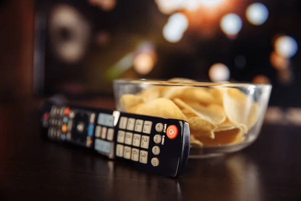 Snacks dan remote control Tv di meja. — Stok Foto