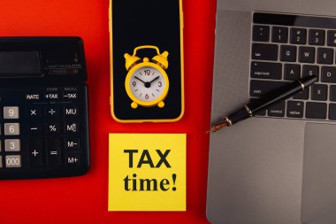 Vergi zamanı - vergi beyannamesi, vergi beyannamesi, işyerindeki vergi formu. Renkli arkaplanda dizüstü bilgisayarı, kalemi ve akıllı telefonu olan hesap makinesi