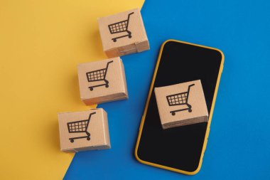 İnternetten alışveriş konsepti. Mavi sarı arka planda dört küçük kutulu akıllı telefon.