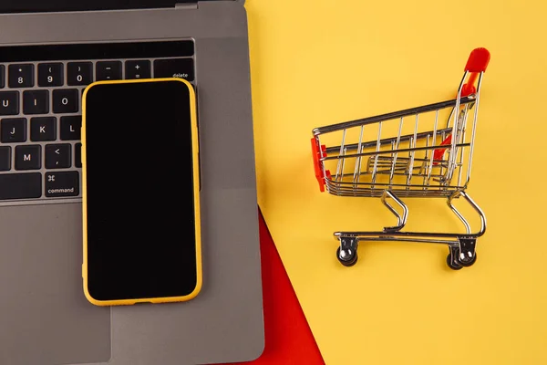 Online-Einkaufskonzepte mit Einkaufswagen und Smartphone am Laptop. E-Commerce-Markt. Transportlogistik. Einzelhandel — Stockfoto