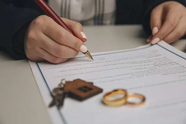 Hands of wife, husband signing decree of divorce, dissolution, canceling marriage, legal separation documents, filing divorce papers or premarital agreement prepared by lawyer. Wedding ring — Stock Photo, Image